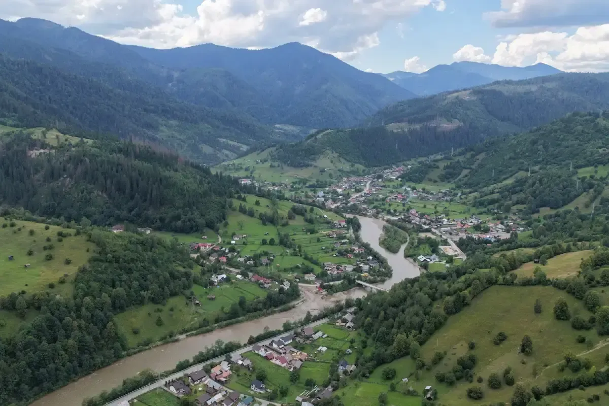 Confluența Negrei cu Bistrița la Broșteni, văzută din dronă: localitatea întinsă pe vale, între versanți împăduriți
