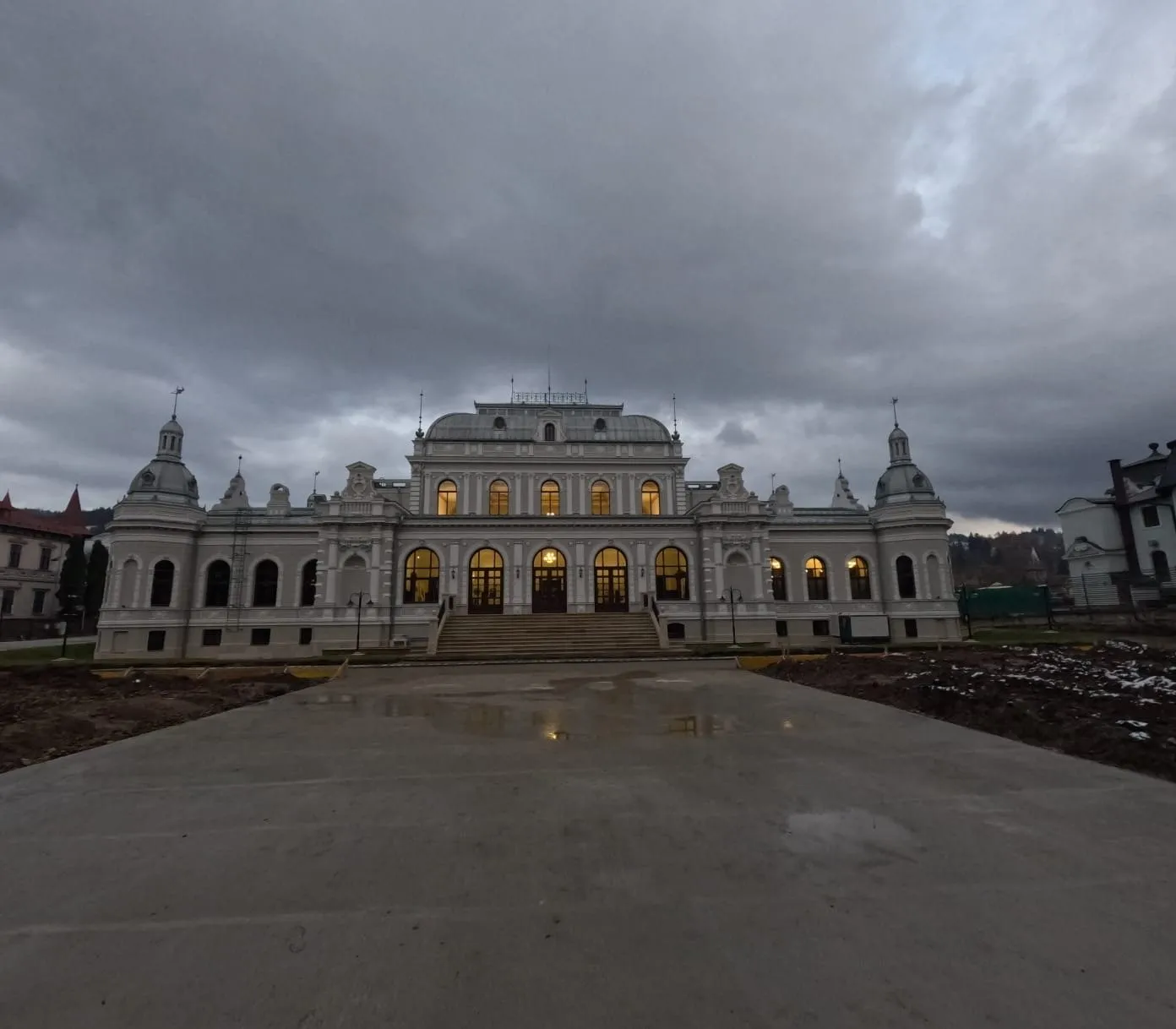 Fațada principală a Cazinoului Băilor din Vatra Dornei, restaurată, cu ferestrele luminate la căderea serii