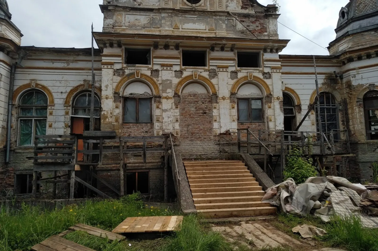Fațada Cazinoului înainte de restaurare, cu tencuiala căzută, ferestre astupate și scara de la intrare degradată